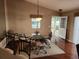 Dining room with a glass table, open doorway, hardwood floors, and a decorative pendant light fixture at 2523 Mariel Way, The Villages, FL 32162