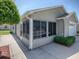 Exterior view of a house with an enclosed lanai, showing the home's neutral siding and clean design at 2523 Mariel Way, The Villages, FL 32162