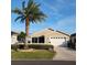 Charming single-story home with a well-manicured lawn and a beautiful palm tree in the front yard at 2523 Mariel Way, The Villages, FL 32162