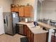 Kitchen featuring stainless steel appliances, wood cabinets, and a bar area with seating at 2523 Mariel Way, The Villages, FL 32162