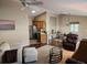 Spacious living room featuring hardwood floors, a ceiling fan, and a bar area with seating at 2523 Mariel Way, The Villages, FL 32162