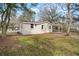 The backyard shows a single story home with an open, green lawn and mature trees at 820 N Carroll Rd, Lakeland, FL 33801