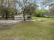 Aerial view of a single story home with an open backyard, lawn, and mature trees at 820 N Carroll Rd, Lakeland, FL 33801