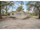 Back of a single story home with open yard and mature trees at 820 N Carroll Rd, Lakeland, FL 33801