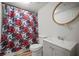 Bathroom with a modern vanity, round framed mirror, a toilet, and a colorful floral shower curtain at 820 N Carroll Rd, Lakeland, FL 33801