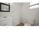 Bathroom with a modern vanity, square framed mirror, and a toilet against a white wall at 820 N Carroll Rd, Lakeland, FL 33801