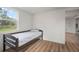 Minimalist bedroom with laminate flooring, a twin bed, and a large window offering views of the backyard at 820 N Carroll Rd, Lakeland, FL 33801