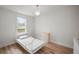 Bright bedroom with modern light fixture, wood-look flooring, and a window with view to the outdoors at 820 N Carroll Rd, Lakeland, FL 33801