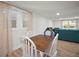 Bright dining area features a wooden table, white chairs, and is adjacent to the living room with comfortable teal sofa at 820 N Carroll Rd, Lakeland, FL 33801