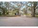 Street view of a quaint single-story home, mature trees, and a fenced front yard at 820 N Carroll Rd, Lakeland, FL 33801