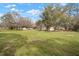 Expansive front yard featuring mature trees and a well-maintained lawn, providing a serene and inviting atmosphere at 820 N Carroll Rd, Lakeland, FL 33801