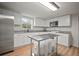 Modern white kitchen with stainless steel appliances, granite countertops, and wood-look flooring at 820 N Carroll Rd, Lakeland, FL 33801