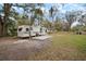 RV set in a serene lot, featuring a concrete patio and the shade of mature trees, perfect for outdoor relaxation at 820 N Carroll Rd, Lakeland, FL 33801