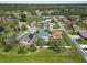 Aerial view of a home with screened pool and solar panels in a residential neighborhood with nearby ponds and lush landscaping at 913 Parasol Pl, Kissimmee, FL 34759