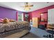 Cozy bedroom featuring unique purple and pink walls, a ceiling fan, and neutral furnishings at 913 Parasol Pl, Kissimmee, FL 34759