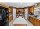 Well-lit kitchen with wood cabinets, an island, and stainless steel appliances at 913 Parasol Pl, Kissimmee, FL 34759