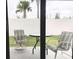 Enclosed lanai offering a serene outdoor space with comfortable seating and view to palm trees at 1974 Lockett Ln, The Villages, FL 34762