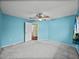 Bedroom with light blue walls, carpet, a ceiling fan, and a door to a bathroom at 222 Carpenters Way # 9, Lakeland, FL 33805