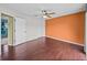 Bedroom showcasing a ceiling fan, closet, hardwood floor and contrasting orange accent wall at 222 Carpenters Way # 9, Lakeland, FL 33805