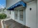 Gray double doors with a blue awning and small wood deck at 222 Carpenters Way # 9, Lakeland, FL 33805