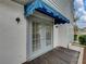 Gray double doors with a blue awning and small wood deck at 222 Carpenters Way # 9, Lakeland, FL 33805