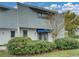 Condo exterior with blue awning, mature tree and partial view of the backyard at 222 Carpenters Way # 9, Lakeland, FL 33805