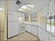 White kitchen appliances and cabinets complemented by a skylight providing bright natural light at 222 Carpenters Way # 9, Lakeland, FL 33805