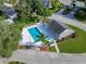 Aerial shot of a pool area with lounge chairs, a building with a gray roof, and surrounding green spaces at 222 Carpenters Way # 9, Lakeland, FL 33805