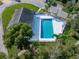 Aerial view of a community pool with ample deck space, surrounded by lush landscaping and a nearby building at 222 Carpenters Way # 9, Lakeland, FL 33805