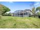 Spacious backyard featuring a large screened-in patio, lush green lawn, and a well-maintained fence at 5406 Baytowne Place, Oviedo, FL 32765
