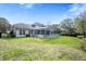 Expansive backyard showcasing a screened-in pool area, manicured lawn, and a charming home exterior at 5406 Baytowne Place, Oviedo, FL 32765