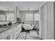 A stunning bathroom boasts double sinks, a freestanding tub, modern fixtures, and a glass walk-in shower at 5406 Baytowne Place, Oviedo, FL 32765