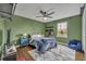 This green bedroom features a white rug, a blue quilt and throw, and a modern ceiling fan at 5406 Baytowne Place, Oviedo, FL 32765