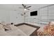 Inviting living area featuring a large sofa, ceiling fan, built-in shelving, and a mounted TV at 5406 Baytowne Place, Oviedo, FL 32765