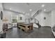 Bright and airy living room features a billiard table, modern staircase, and neutral decor at 5406 Baytowne Place, Oviedo, FL 32765