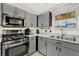 Kitchen featuring stainless steel appliances, sleek gray cabinetry, and efficient layout at 2337 St George Ave, The Villages, FL 32162