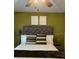 Comfortable bedroom with a tufted headboard and a bright olive accent wall at 858 Lafayette Ln, Lakeland, FL 33805