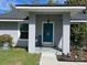 Charming home exterior with a covered front porch, stone pillars, and a teal-colored front door at 858 Lafayette Ln, Lakeland, FL 33805