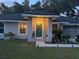 Charming home featuring a teal door, lovely landscaping, and well-lit walkway at 858 Lafayette Ln, Lakeland, FL 33805