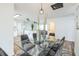 Dining area open to the kitchen, with clear glass table, seating for six, and modern light fixtures at 1729 Elk Dr, Lakeland, FL 33801
