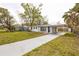 Attractive single-story home with gray driveway and an attached, covered carport on a landscaped lot at 1729 Elk Dr, Lakeland, FL 33801