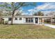Charming single-story home features a covered carport, fresh white paint, and beautiful landscaping at 1729 Elk Dr, Lakeland, FL 33801