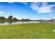 Expansive backyard offers tranquil water views and a well-maintained lawn, enhanced by a secure fence at 4381 Pumice Dr, Lakeland, FL 33811