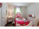 A bedroom with white furniture and a bright pink patterned bedspread at 9636 Water Fern Cir, Clermont, FL 34711