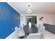 Elegant dining area with modern chandelier, decorative blue wall, and seamless access to outdoor space at 2956 Penelope Loop, Kissimmee, FL 34746