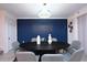 Stylish dining room featuring a dark wood table, elegant chandelier, and a decorative blue accent wall at 2956 Penelope Loop, Kissimmee, FL 34746