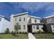 Charming modern home featuring a red front door, stone accents, and landscaped front yard at 2956 Penelope Loop, Kissimmee, FL 34746