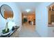Bright hallway with decorative mirror, white walls, and an open view of the modern kitchen at 2956 Penelope Loop, Kissimmee, FL 34746