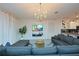 Bright and airy living room with modern decor, a comfortable gray sofa, and a flat screen television at 2956 Penelope Loop, Kissimmee, FL 34746
