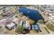 Aerial view showcasing tennis and shuffleboard courts, a lake with fountain, and community buildings at 5006 Lodgewood Dr, Lakeland, FL 33810